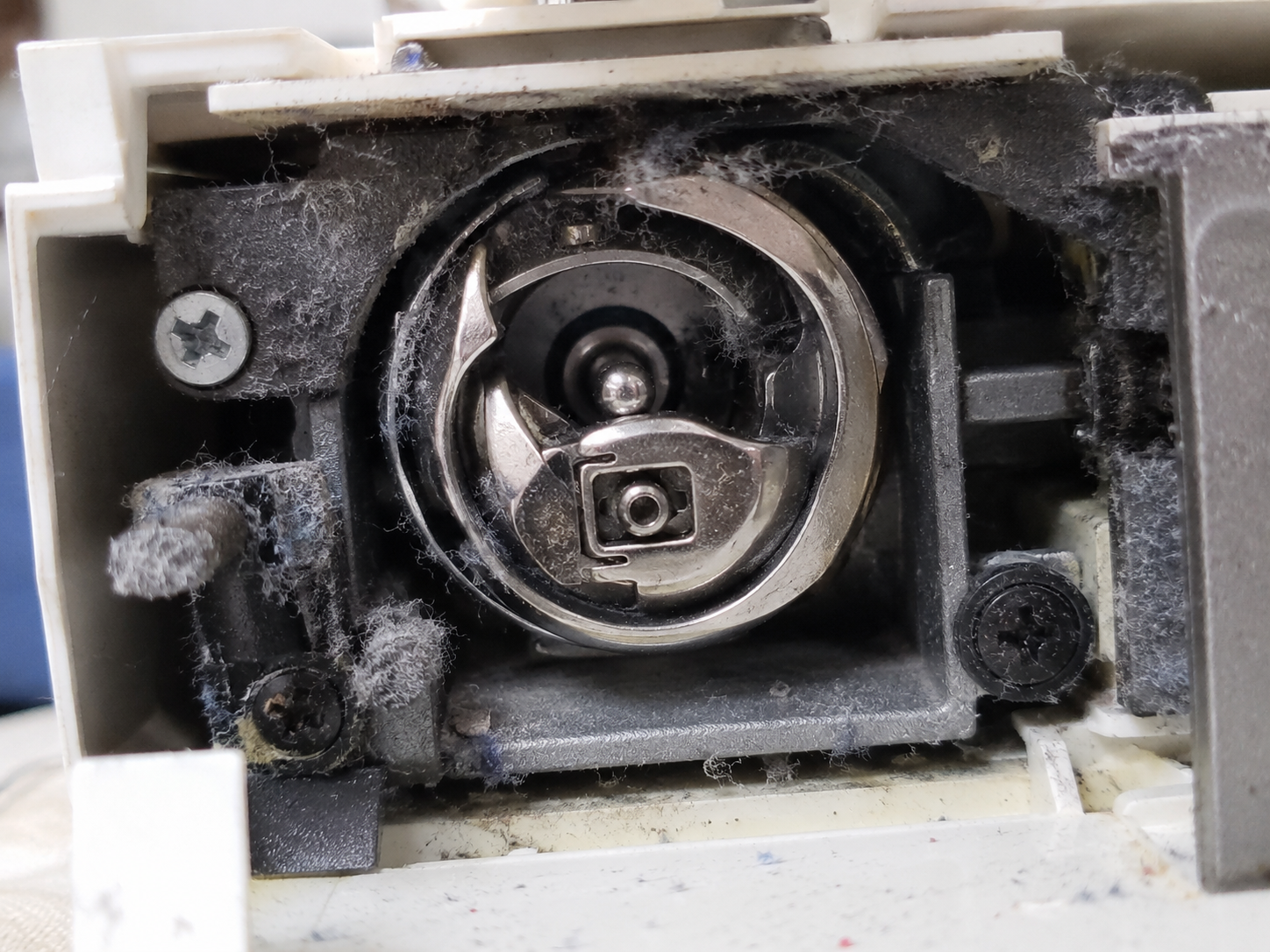 Gancho rotativo de máquina de coser con pelusa acumulada